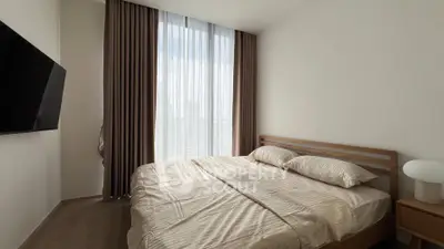 Modern bedroom with large window and stylish decor in a contemporary apartment.