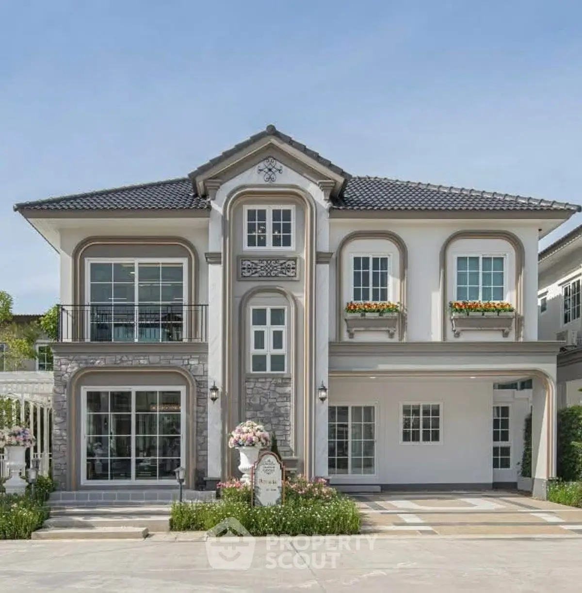 Elegant two-story house with classic facade and lush landscaping