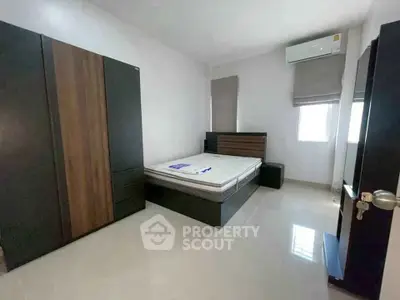 Modern bedroom with sleek furniture and air conditioning in a minimalist design.