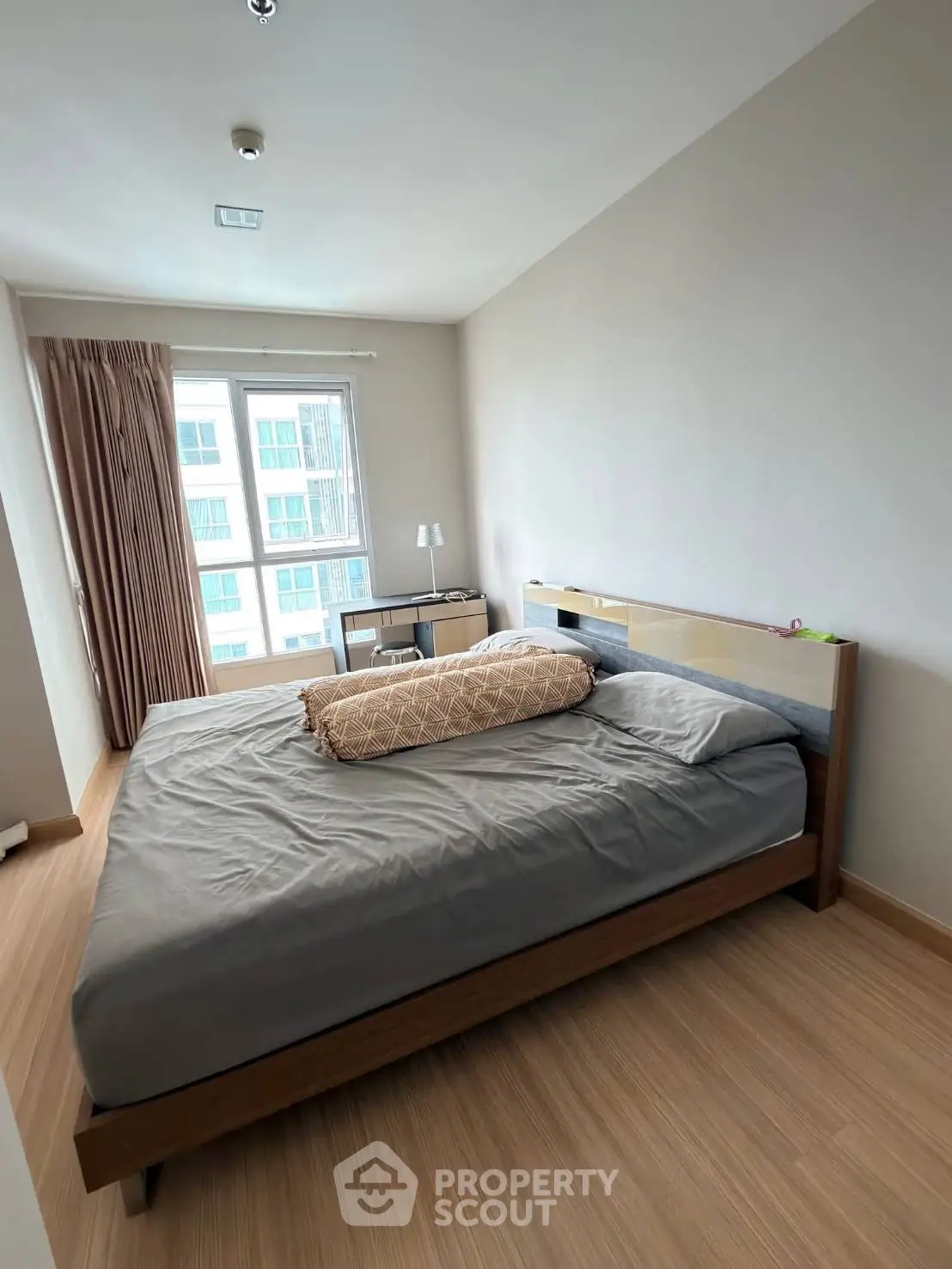 Modern bedroom with large window and stylish wooden flooring