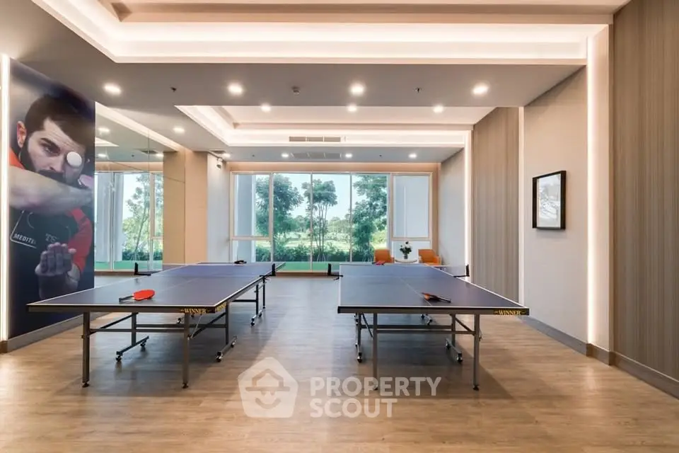 Modern recreational room with table tennis setup and stylish lighting, perfect for leisure activities.