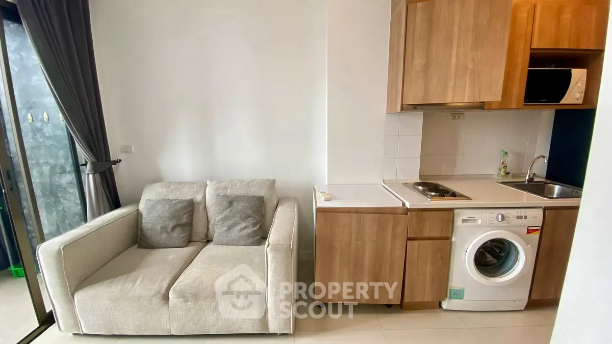 Cozy modern living room with compact kitchen and washing machine