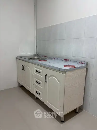 Modern kitchen with sleek cabinetry and tiled backsplash, perfect for culinary enthusiasts.