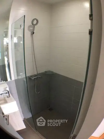 Modern bathroom with glass shower enclosure and sleek fixtures.