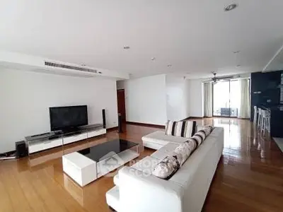 Spacious modern living room with sleek furniture and wooden flooring in a luxury apartment.
