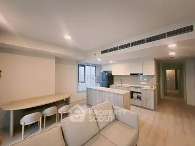 Modern open-plan kitchen and living room with sleek design and ample natural light.