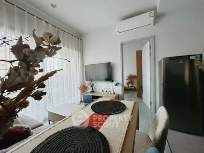 Modern living room with stylish decor, air conditioning, and natural light from large windows.