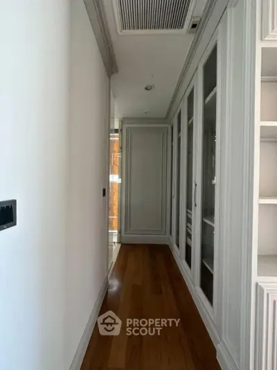Elegant hallway with wooden flooring and built-in storage cabinets