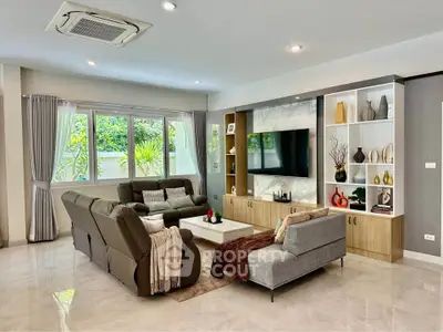 Spacious modern living room with elegant decor and large windows offering natural light.