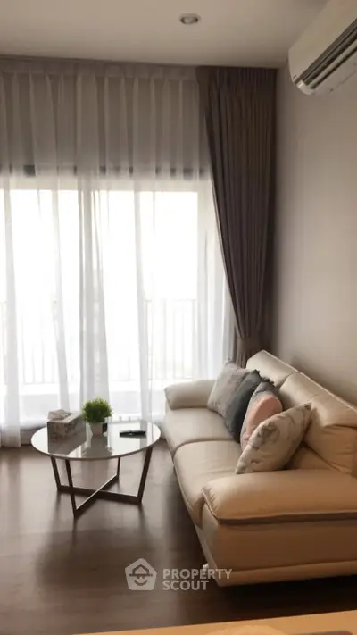 Modern living room with elegant sofa and floor-to-ceiling windows, offering a cozy and inviting atmosphere.