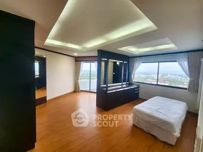 Spacious bedroom with large windows offering stunning city views and modern design.