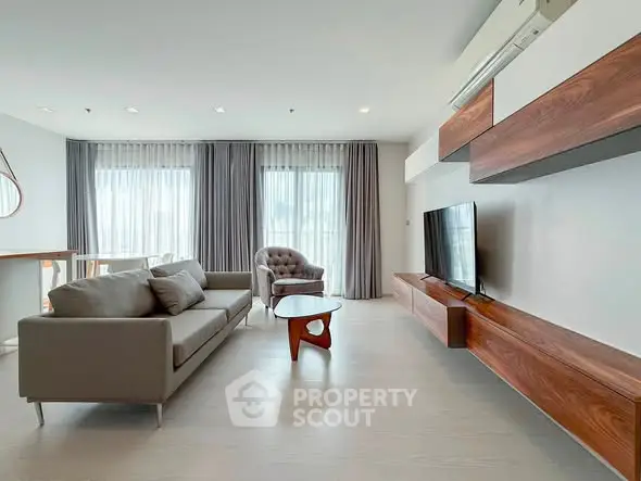 Spacious modern living room with elegant furniture and large windows for natural light.