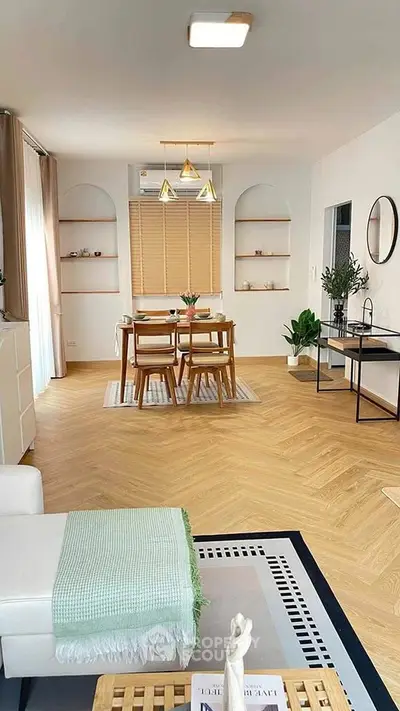 Modern open-plan living and dining area with stylish decor and wooden flooring.