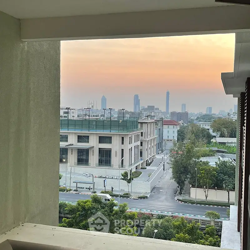 Stunning cityscape view from a modern balcony at sunset, showcasing urban skyline and serene surroundings.