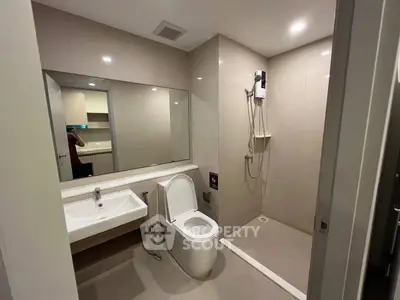 Modern bathroom with sleek design, featuring a spacious shower and contemporary fixtures.