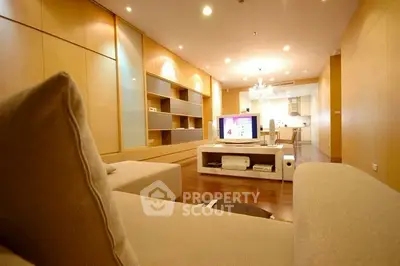 Spacious modern living room with elegant lighting and open kitchen layout.