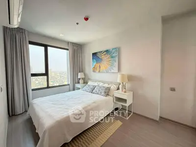Modern bedroom with city view, stylish decor, and ample natural light.