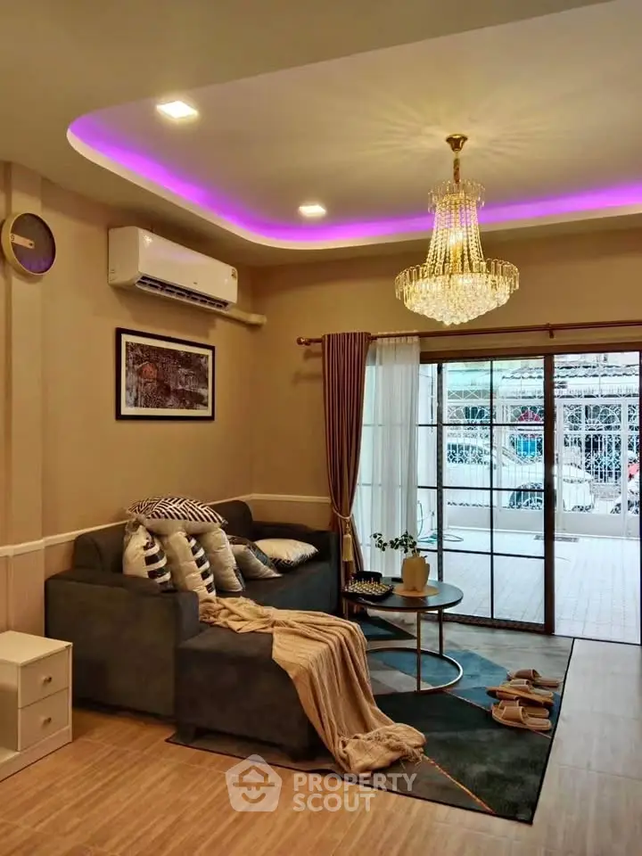 Luxurious living room with modern decor, elegant chandelier, and cozy seating area.