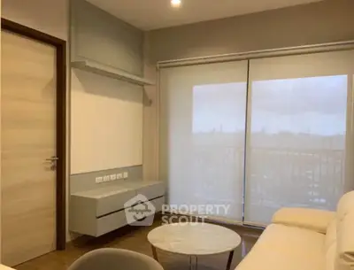 Modern living room with sleek furniture and large windows offering natural light.