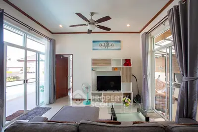 Spacious living room with modern decor and large windows for natural light