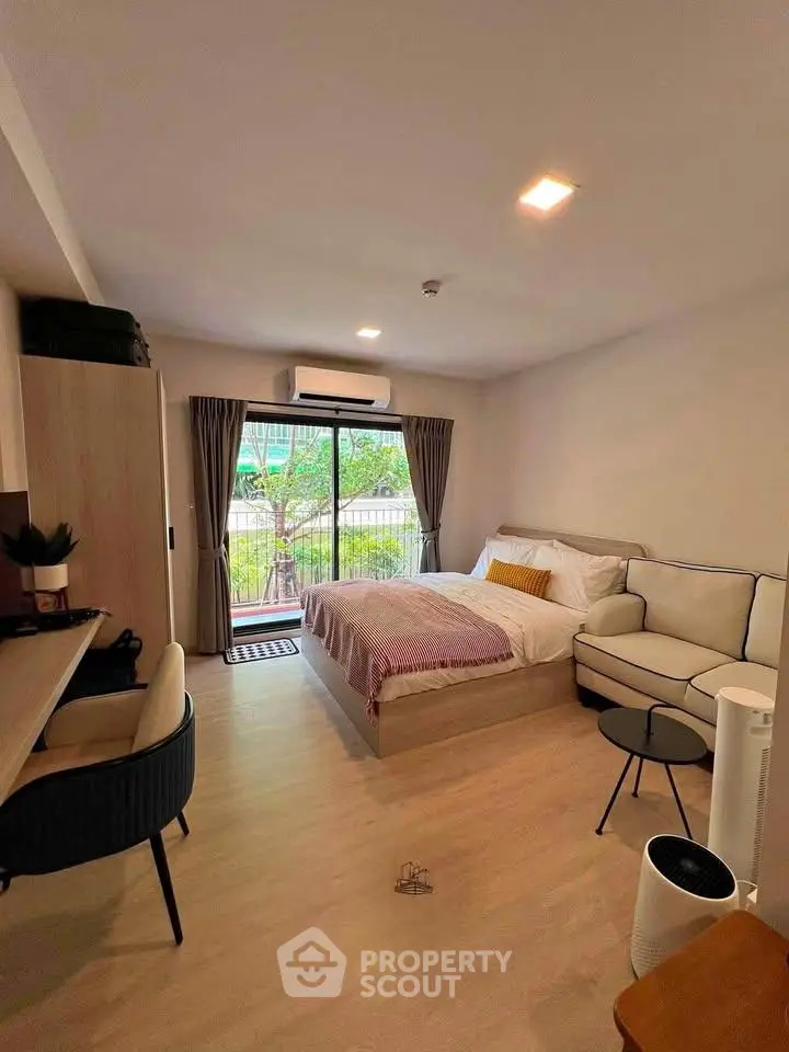 Modern studio apartment with cozy bedroom and living area, featuring a balcony with a view.