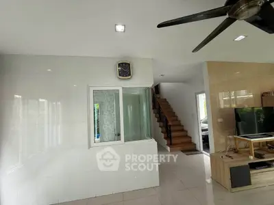 Spacious modern living room with sleek design and staircase leading to upper floor.