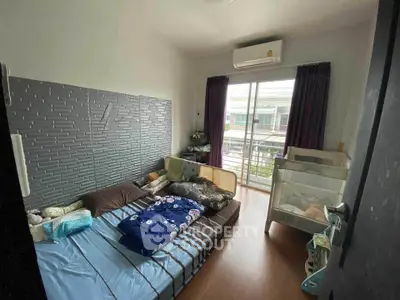 Cozy bedroom with balcony access and modern air conditioning unit.