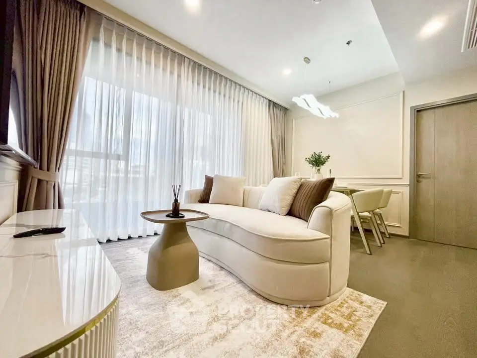 Luxurious living room with elegant curved sofa and modern decor, perfect for relaxation and entertaining.