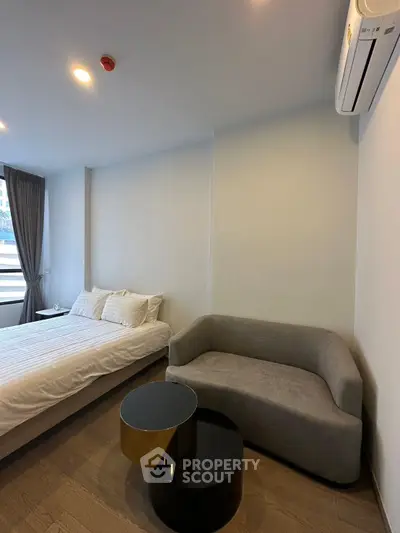 Modern bedroom with cozy sofa and stylish decor in a contemporary apartment.