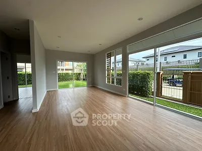 Spacious empty living room with large windows and wooden flooring in modern home