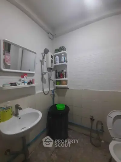 Compact bathroom with essential fixtures and storage shelves