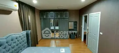 Spacious bedroom with elegant furniture and ample closet space in modern apartment.