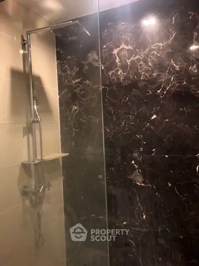 Luxurious marble shower with modern fixtures in elegant bathroom setting.