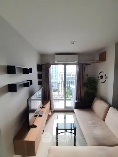Modern living room with balcony view, sleek furniture, and wall-mounted TV in a stylish apartment.