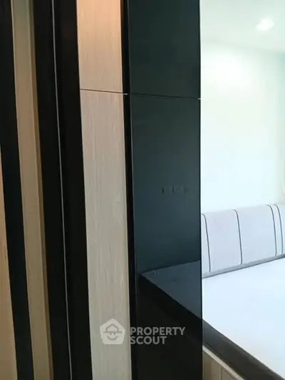 Modern bedroom with sleek black wardrobe and stylish bed design