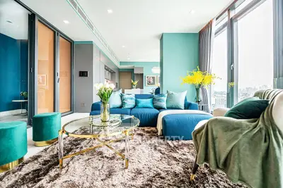 Luxurious modern living room with plush blue sofa and panoramic city views.