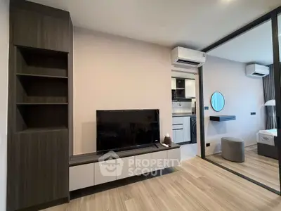 Modern living room with sleek furniture and open kitchen layout in a stylish apartment.