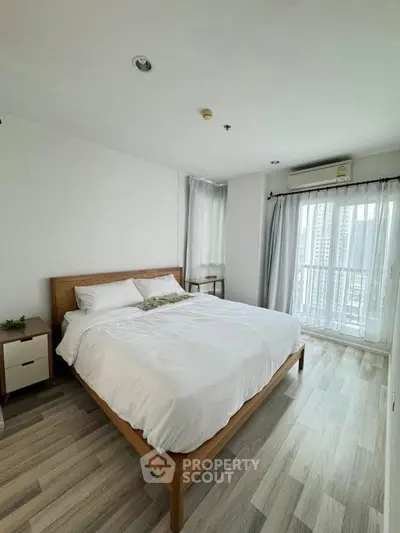 Bright and airy bedroom with modern decor and city view balcony access.