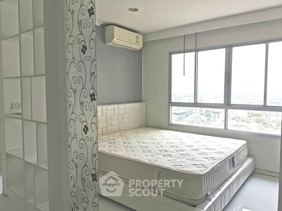 Bright bedroom with large window and air conditioning, featuring a comfortable mattress and stylish decor.