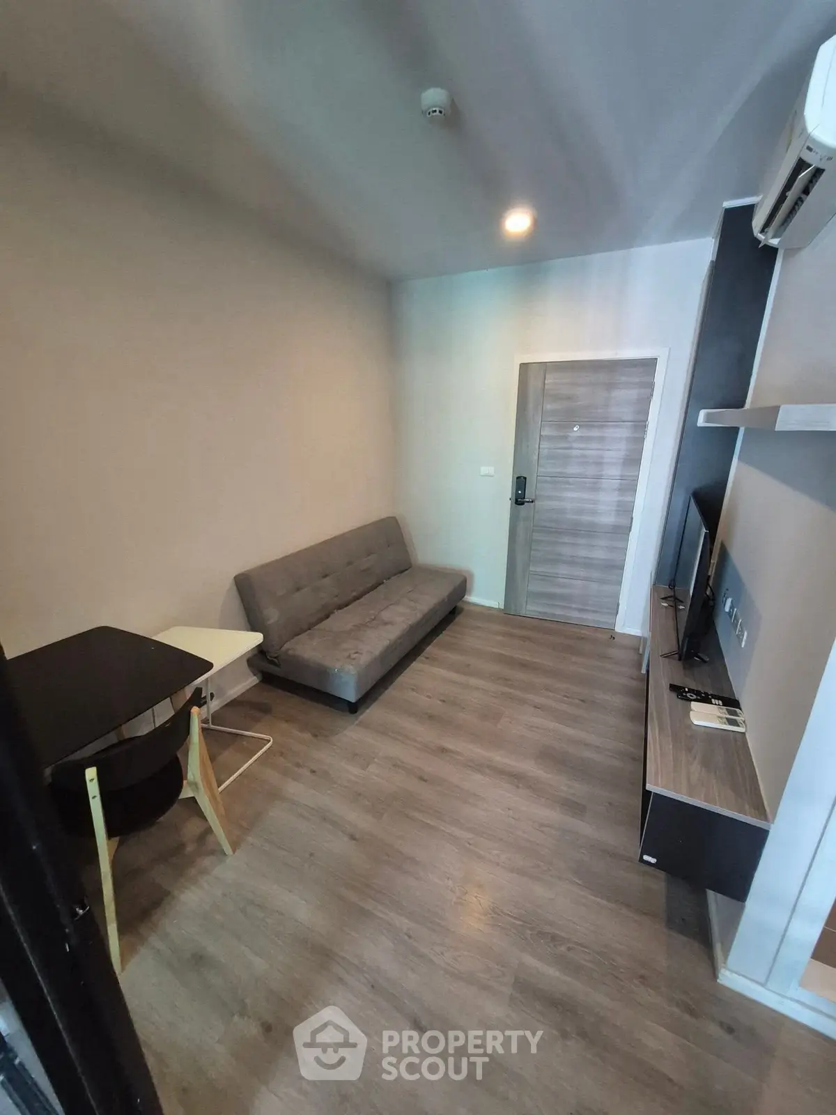 Modern living room with sleek furniture and wooden flooring in a cozy apartment.