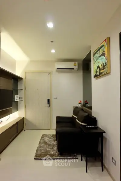 Modern living room with sleek furniture and wall-mounted TV in a cozy apartment.