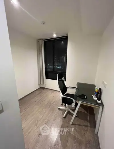 Modern study room with sleek desk and ergonomic chair, featuring a large window with city night view.