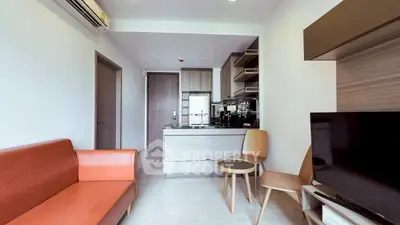Modern living room with open kitchen, stylish furniture, and air conditioning.