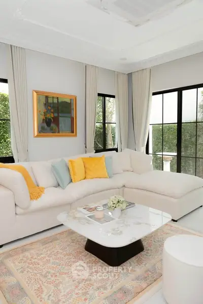 Elegant living room with large windows, cozy sectional sofa, and stylish decor