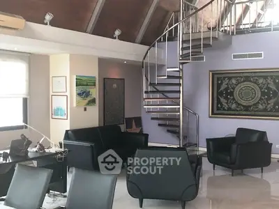 Luxurious living room with spiral staircase and modern black furniture in a stylish open-plan design.