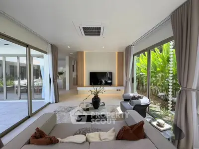 Luxurious living room with modern decor and large windows overlooking a lush garden, perfect for relaxation.