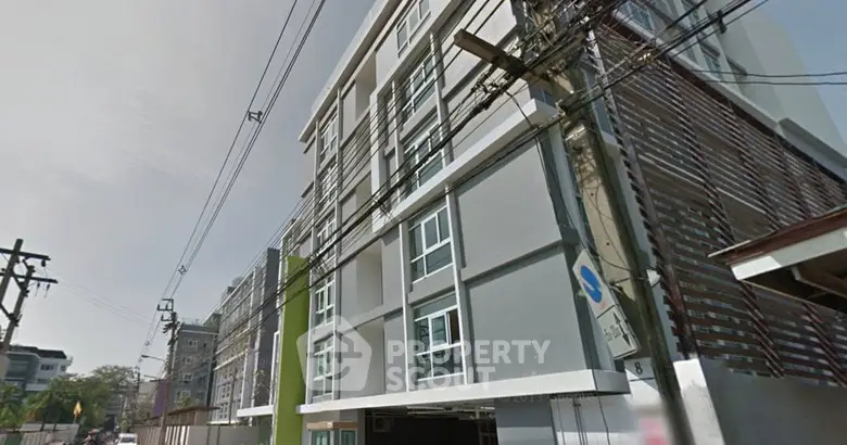 Modern multi-story building exterior with sleek design and large windows in urban setting.
