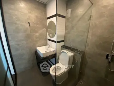 Modern bathroom with sleek design featuring a glass shower and contemporary fixtures.