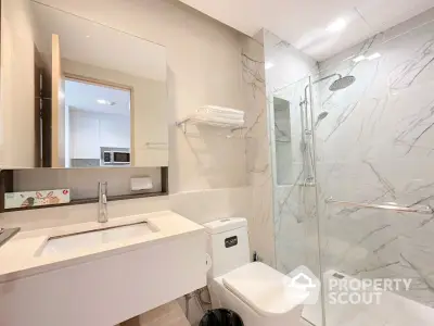 Modern bathroom with glass shower and sleek fixtures in a contemporary home.