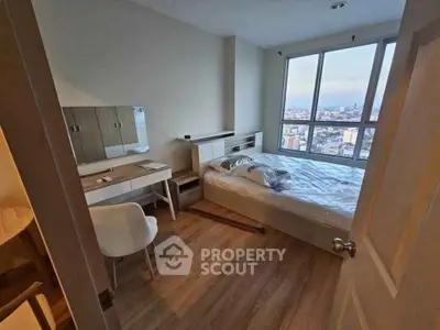 Modern bedroom with city view, featuring a cozy bed, stylish desk, and large windows for natural light.